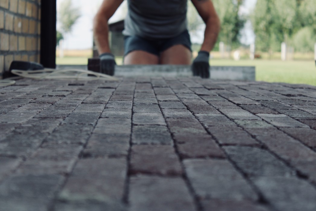 home improvement man paving a brick pavement putting in a brick floor outdoors for a terrace low view t20 WxbzKK